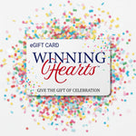 A white eGift card for Winning Hearts, featuring navy blue and red lettering, with colorful confetti scattered around the edges on a white background.